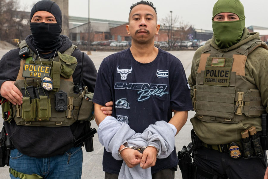 U.S. Immigration and Customs Enforcement Enforcement and Removal Operations (ICE ERO) officers escort 27-year-old David Alejandro Orellana‑Aleman during his arrest in Hyattsville, Maryland, on February 27. Orellana‑Aleman, a Salvadoran national and alleged high-ranking MS‑13 leader who reportedly controlled gang operations in the United States, Mexico, and Europe, is handcuffed and flanked by law-enforcement agents wearing tactical gear. The image, released March 3, shows a nondescript background consistent with a parking lot or open area, reflecting the moment of his apprehension 