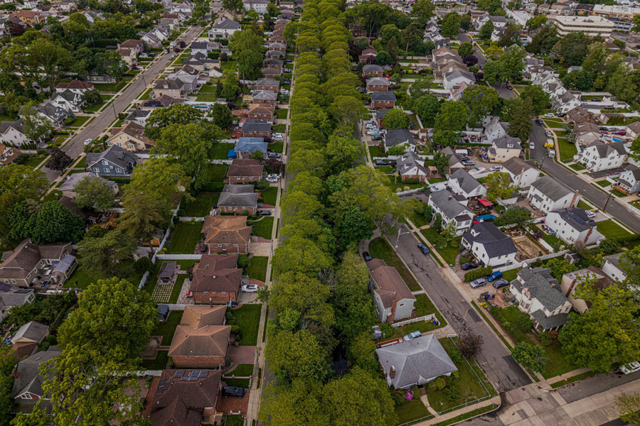 This aerial stock photo showcases a picturesque residential neighborhood in Lynbrook, New York. Tree-lined streets divide neatly arranged rows of single-family homes, reflecting the village’s suburban charm and well-kept appearance. The image highlights the community’s blend of classic and modern architecture, green spaces, and peaceful atmosphere, all while being conveniently located near Long Island’s bustling commercial and commuter hubs.