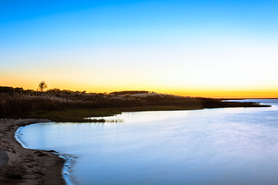 A tranquil sunset over the Great South Bay, reflecting the scenic South Shore landscapes accessible via Nicolls Road. The highway’s southern terminus at Blue Point connects travelers directly to Long Island’s coastal marshes, beaches, and waterfront views.
