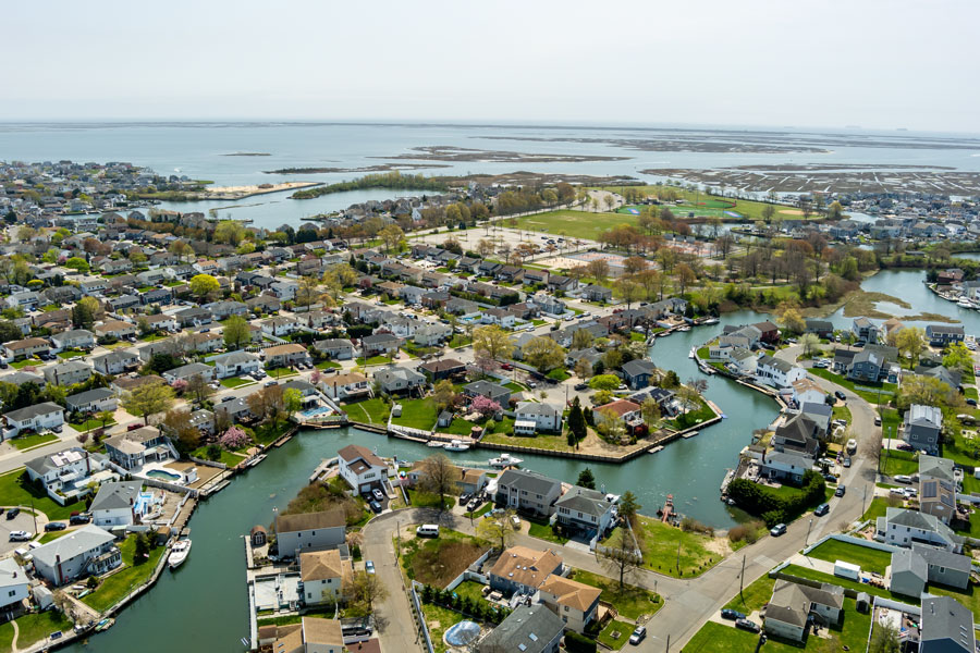 An aerial view of Seaford, New York, showcasing its scenic waterfront homes, winding canals, and access to South Oyster Bay. The image highlights the community’s unique blend of suburban neighborhoods and coastal living, with nearby parks and waterways that make Seaford a sought-after destination for boating and recreation.