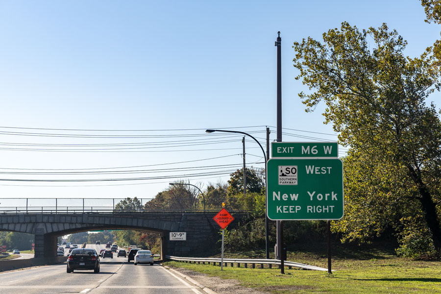 Westbound view along the Meadowbrook State Parkway at Exit M6W, where drivers can connect to the Southern State Parkway westbound toward Queens and New York City. The MSP’s “M” exit numbering system is unique to the road, with exits increasing as the parkway continues south toward Jones Beach.