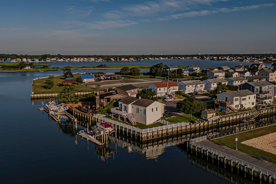 An aerial view of a marsh land area with blue skies and clouds. Taken over the horizon in Baldwin Bay in the morning by Waterfront Park in Freeport, NY.
