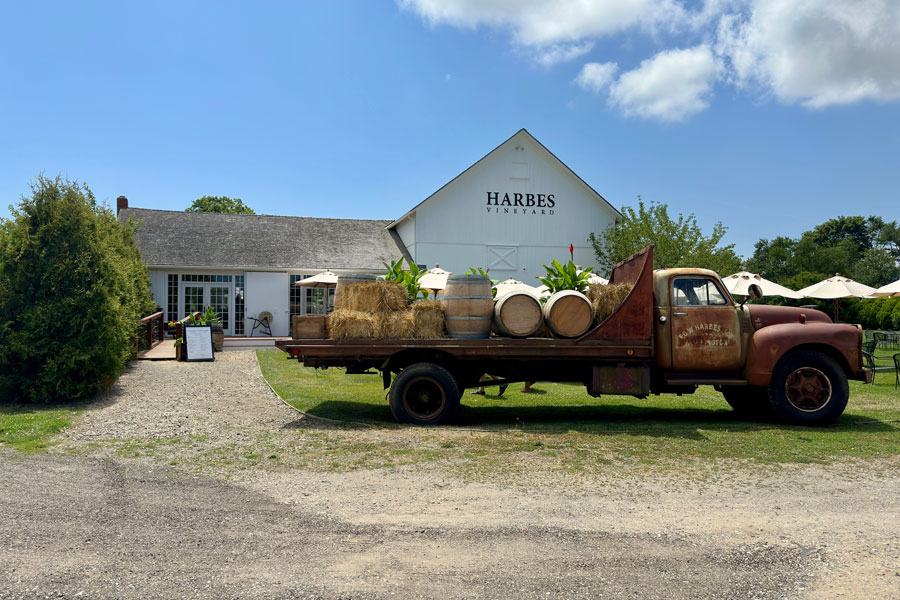 Harbes Vineyard is a well-known winery in Mattituck, Long Island, specializing in estate-grown wines and agritourism experiences. The vintage truck adorned with farm items in front of the tasting room is a signature detail, contributing to the area's rural charm and agrarian tradition.