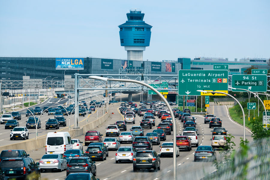 LaGuardia Airport (LGA), one of New York City’s primary air travel hubs located in Queens. The photo shows traffic congestion on the highway leading to the terminals, reflecting the airport’s vital role in handling millions of passengers each year. Rising prominently above the scene is the Air Traffic Control Tower, overseeing operations across the runways. In recent years, LaGuardia has undergone a major multibillion-dollar redevelopment, replacing outdated terminals with modern facilities designed to improve efficiency and passenger experience. Once criticized for its aging infrastructure, today’s new LGA stands as a state-of-the-art gateway for domestic travel and short-haul international flights serving the New York metropolitan area.