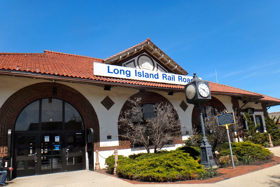 The exterior of the Long Beach Long Island Railroad station in Long Beach, NY, taken on April 16, 2016. The station features a classic architectural style with arched windows and a prominent clock outside, part of the Long Island Rail Road commuter network. 