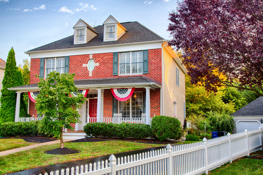 A colonial house in Medford with American Flag buntings on the porch.