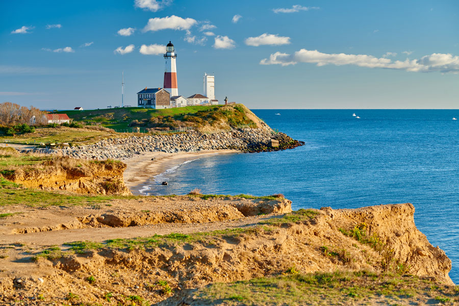 The Montauk Point Lighthouse overlooking the Atlantic Ocean on the eastern tip of Long Island, New York. Surrounded by rocky cliffs and sandy beaches, this historic landmark is the oldest lighthouse in New York State and a symbol of Montauk’s maritime heritage.
