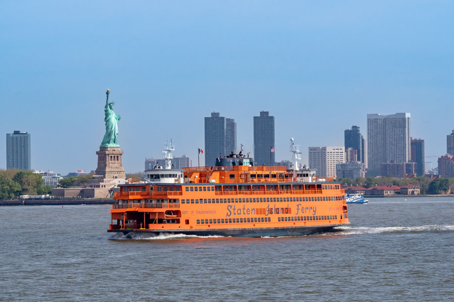 New York, New York, USA - May 14, 2024: Staten Island ferry and the statue of liberty with Manhattan skyline.