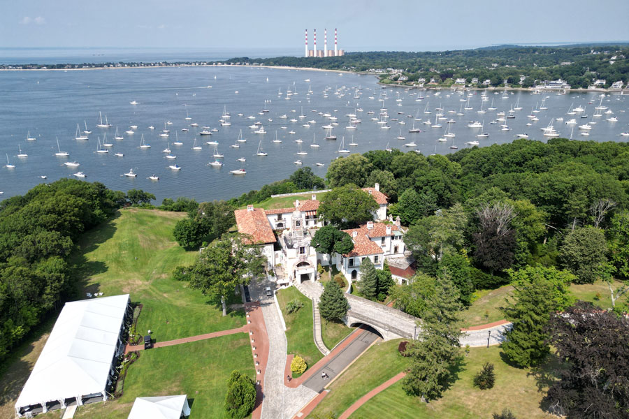 Aerial view of the Vanderbilt Museum and Planetarium in Centerport, Long Island, New York. Overlooking Northport Bay, the historic estate features Mediterranean-style architecture surrounded by lush grounds. The museum is a popular cultural destination, offering exhibits, tours of the mansion, and a renowned planetarium with panoramic views of the waterfront.