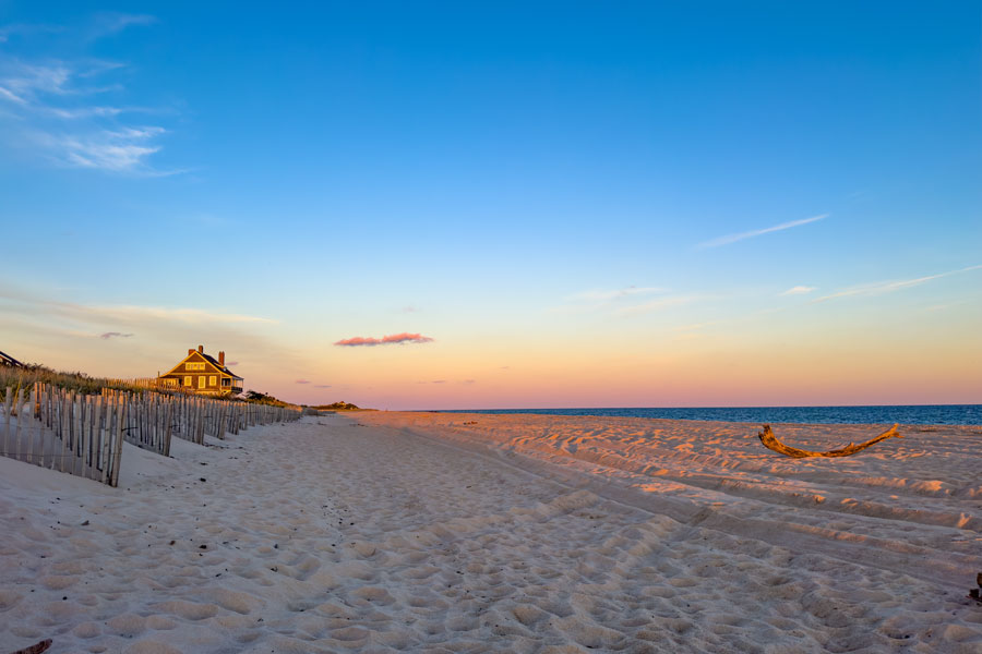 Kilkare mansion glows in the light of sunset, overlooking the pristine sand dunes and empty shoreline of Wainscott Beach in East Hampton, New York. This historic oceanfront home is a landmark on the Hamptons’ South Fork, embodying the peaceful beauty and timeless seascape that make Wainscott a treasured getaway on Long Island’s East End.