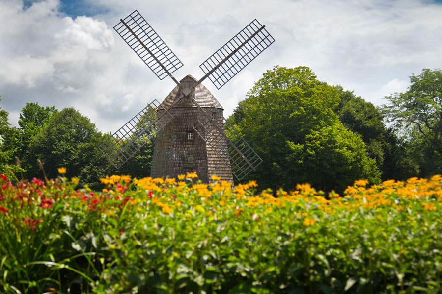The historic windmill at Water Mill, Long Island, New York, surrounded by summer blooms and lush greenery. Built in the early 19th century, this landmark represents the Hamptons’ agricultural past and is one of the many preserved windmills that dot the East End.