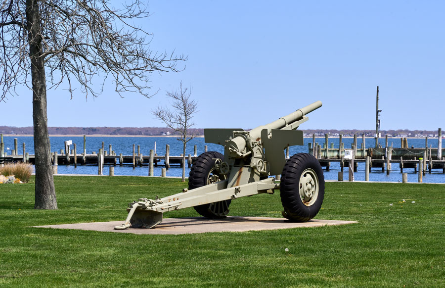An artillery cannon on display at Osborn Park in Bellport, NY, stands against the backdrop of the marina and Great South Bay. This World War II–era piece serves as a local memorial and a reminder of the village’s ties to American history. The tranquil setting of the waterfront contrasts with the monument’s solemn tribute, making it a meaningful landmark for residents and visitors alike.