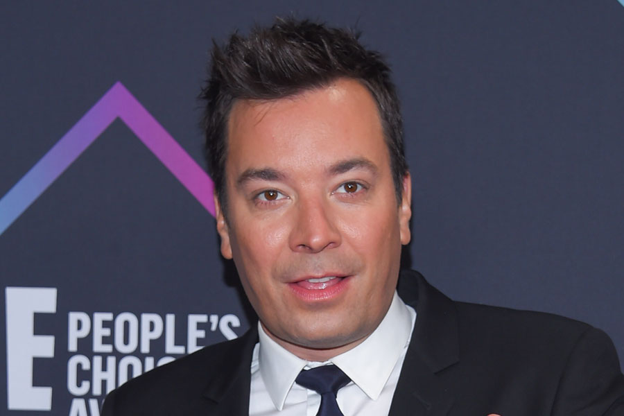 Jimmy Fallon in a black suit and tie posing on the red carpet at the 2018 E! People’s Choice Awards at Barker Hangar in Santa Monica, California.
