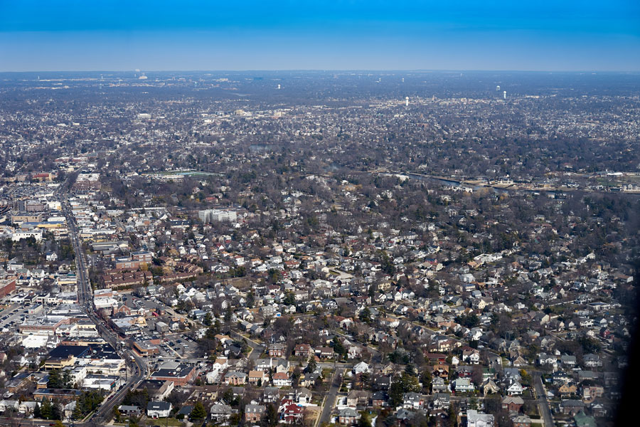 An aerial view captures the suburban landscape of Woodmere, New York, just south of Jamaica, Queens. The photo showcases the dense but peaceful residential character that defines this Nassau County community, part of Long Island’s renowned Five Towns. Rows of tree-lined streets and mixed housing can be seen stretching toward the horizon, illustrating Woodmere’s close proximity to New York City while maintaining a distinctly suburban feel.