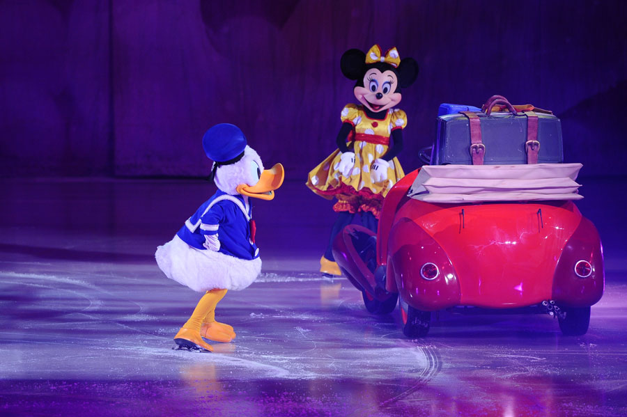 Donald Duck and Minnie Mouse performing on ice beside a small red car during Disney On Ice’s Jump In! show at UBS Arena in Elmont, New York.