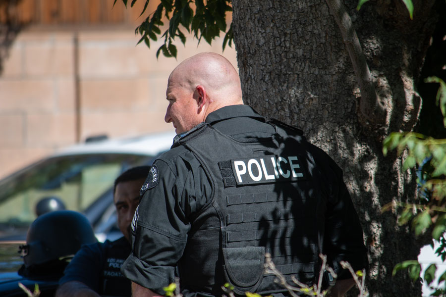 A SWAT police officer stands outside a residence during a narcotics investigation.