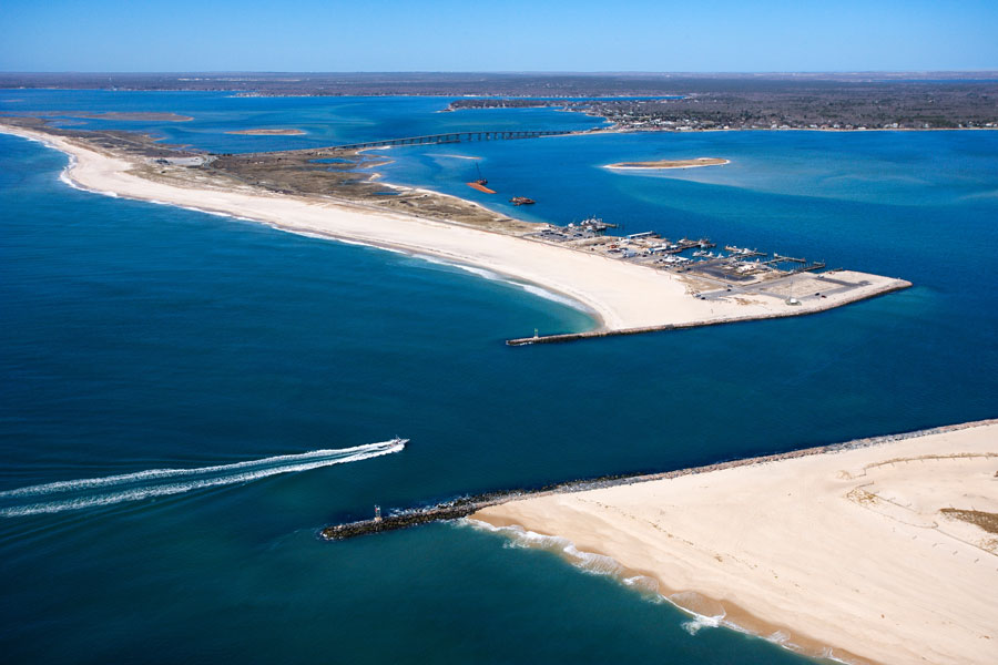 Aerial view of the Shinnecock Inlet and Shinnecock Bay on Long Island, showing boats, sandy barrier beaches, and surrounding waterways.