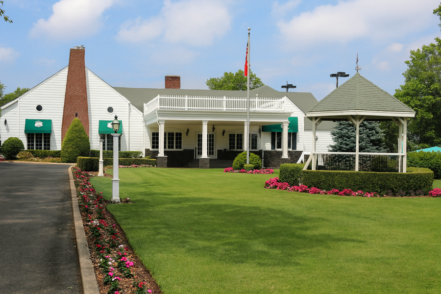 Stewart Manor Country Club with gazebo, landscaped grounds, and white clubhouse on a sunny day.
