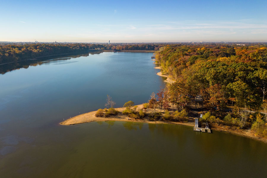 Aerial view of Hempstead Lake State Park in New York, showing calm water, sandy shoreline, and colorful autumn trees, located about four miles from Franklin Square.
