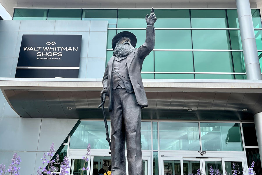 A statue of Walt Whitman stands prominently in front of the Walt Whitman Shops in Dix Hills