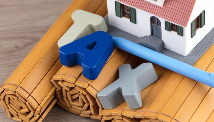 House model and letters spelling tax, representing the New York State STAR school tax relief program for homeowners