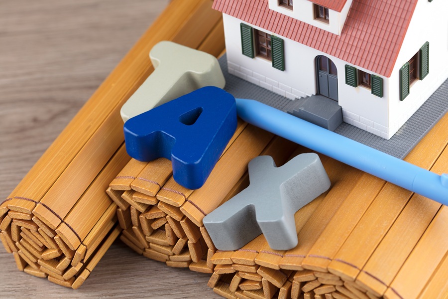 House model and letters spelling tax, representing the New York State STAR school tax relief program for homeowners