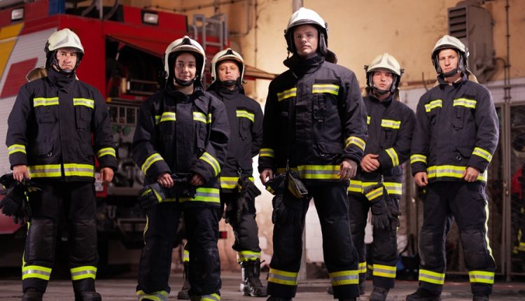 Volunteer firefighters in protective gear inside a firehouse, illustrating Long Island’s volunteer fire department system