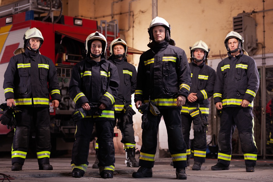 Volunteer firefighters in protective gear inside a firehouse, illustrating Long Island’s volunteer fire department system