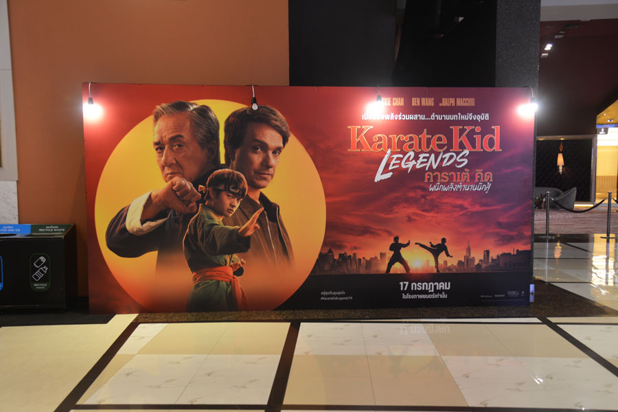 Promotional standee for Karate Kid: Legends displayed inside a movie theater in Bangkok, Thailand, featuring Jackie Chan, Ralph Macchio, and Ben Wang, July 13, 2025.