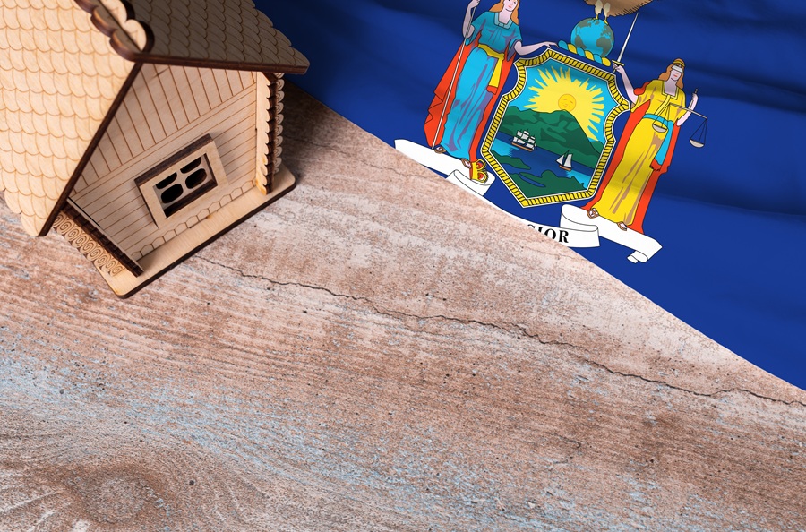 House model and New York State flag representing property tax assessments and grievance deadlines in Nassau and Suffolk counties