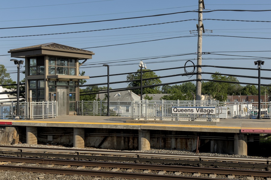 Train station sign showing a village name on Long Island, illustrating how place names do not always reflect municipal structure