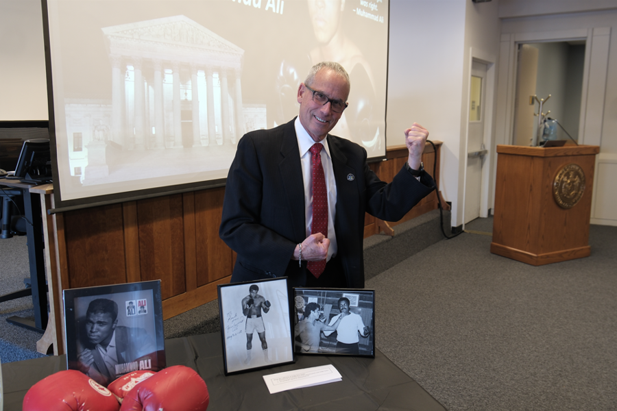 Judge Eric Sachs poses in front of picture of himself with M. Ali
