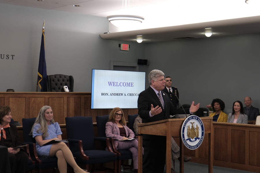 District Administrative Judge Hon. Andrew Crecca gives welcoming remarks to open the Grand Celebration event while judges and judicial staff look on.