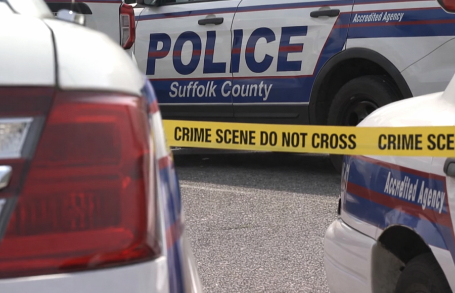 Police vehicles from the Suffolk County Police Department are seen behind crime scene tape during an investigation in Suffolk County, New York. Authorities say detectives are investigating allegations of child abuse connected to a Lindenhurst daycare facility.