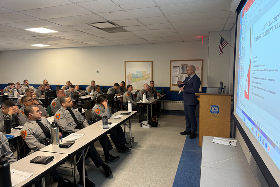 Hon. John Iliou engages with cadets during a discussion on courtroom procedures, emphasizing the importance of understanding the full justice process beyond arrest.