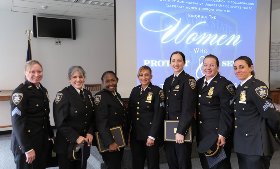 (L-R) Sergeant Ann Marie Calise, Lieutenant Sonia Alvarez, Sergeant Kelly MacDonald, Lieutenant Alyssa Martinez, Major Karen Morro, Chief Eileen Mallon (Ret.), Lieutenant Celeste Forde, Sergeant Evelyn Portes, and Sergeant Janice Hago pose before their ceremonial cake.