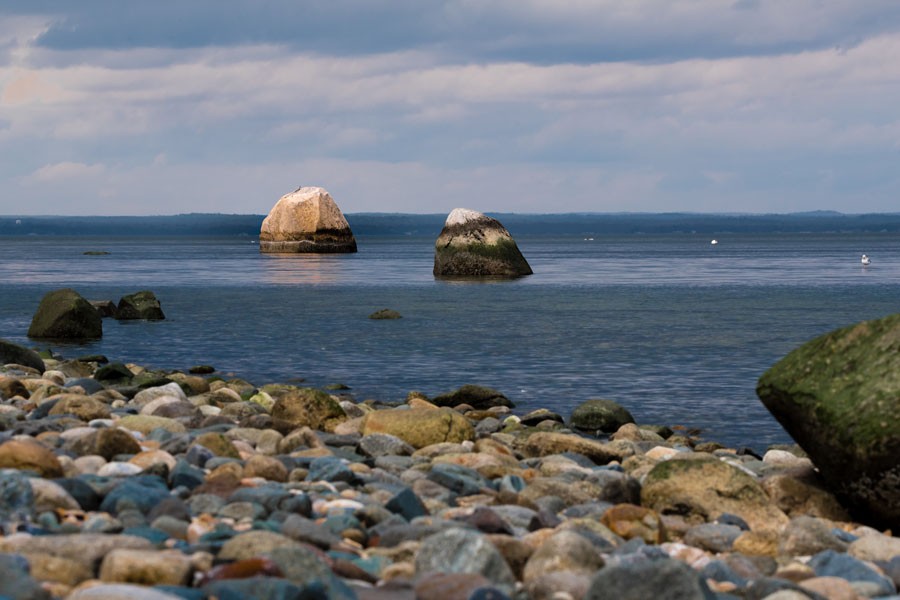 The historic “Target Rock” formations emerge from the Long Island Sound along the shoreline of Target Rock National Wildlife Refuge in Lloyd Harbor, New York. These distinctive boulders are tied to local legend, with stories suggesting they were used for target practice during the Revolutionary War, giving the refuge its name. The surrounding rocky coast and tranquil waters capture the quiet, preserved character of Long Island’s North Shore.