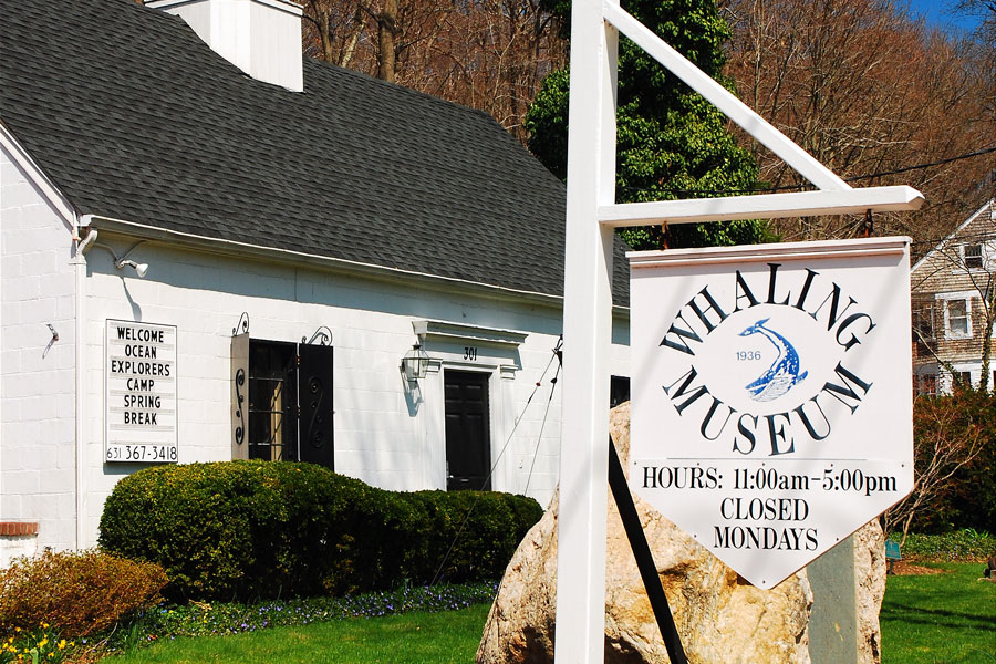 The Whaling Museum & Education Center of Cold Spring Harbor welcomes visitors along Main Street, where its historic building and signature sign reflect the hamlet’s deep maritime roots and longstanding connection to Long Island’s whaling heritage.
