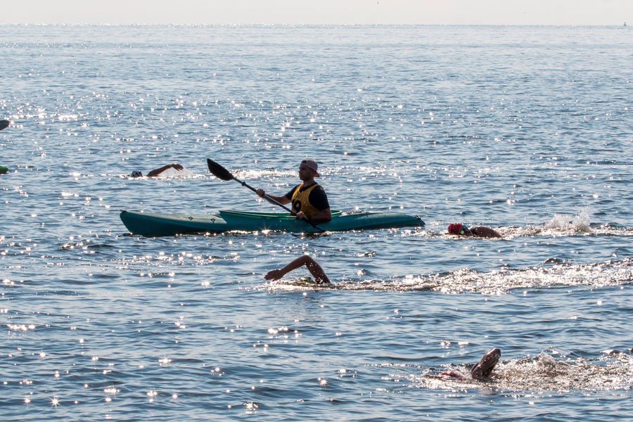 Brightwaters, New York, USA - 14 July 2022: People paddle kayaks while others swim in clear, sunny waters on a warm day.