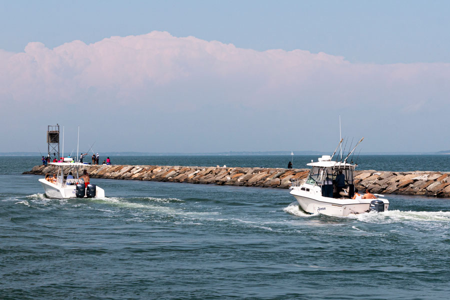 Fishing boats navigate the Shinnecock Canal inlet on eastern Long Island, where the waterway connects Shinnecock Bay with the Peconic Bay system and serves as one of the most important boating and fishing channels in the Hamptons region of Suffolk County, New York.