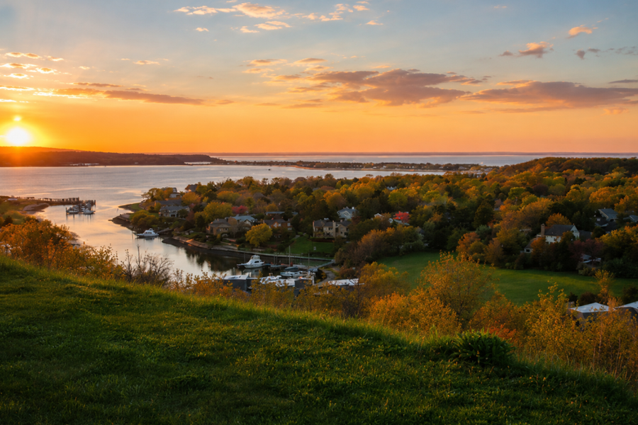 Overlooking Asharoken and Northport Bay at golden hour on Long Island’s North Shore, where wooded hillsides, waterfront homes, and quiet marina inlets meet the calm waters of the Long Island Sound in Suffolk County, New York. This image has been digitally enhanced for color and visual presentation yet based on an actual photograph of the exact area.
