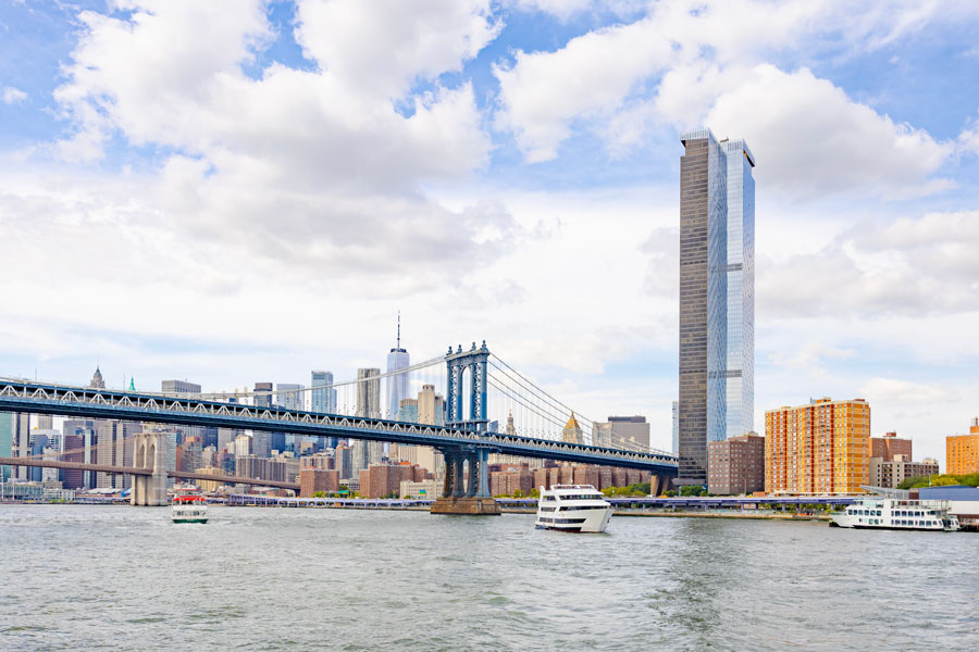 The Hudson River flows past Lower Manhattan and New York City near the entrance to New York Harbor, helping shape one of the world’s most recognizable urban skylines. Seen here are the Brooklyn Bridge, waterfront traffic, and the towering cityscape that marks the western gateway to Long Island and the greater New York metropolitan region.