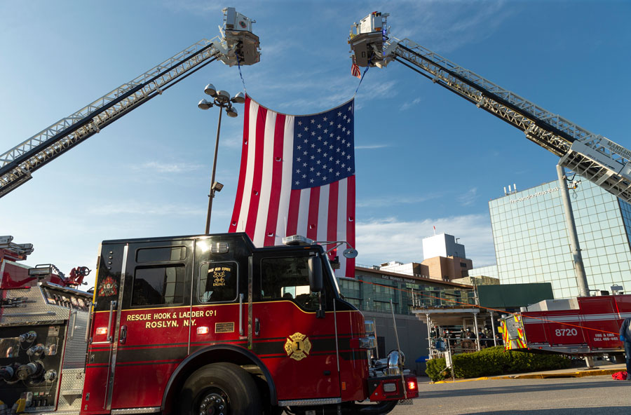 Fire trucks from the Roslyn Rescue Hook & Ladder Company display a large American flag during a community event on Long Island’s North Shore near the Roslyn area of Nassau County, New York.