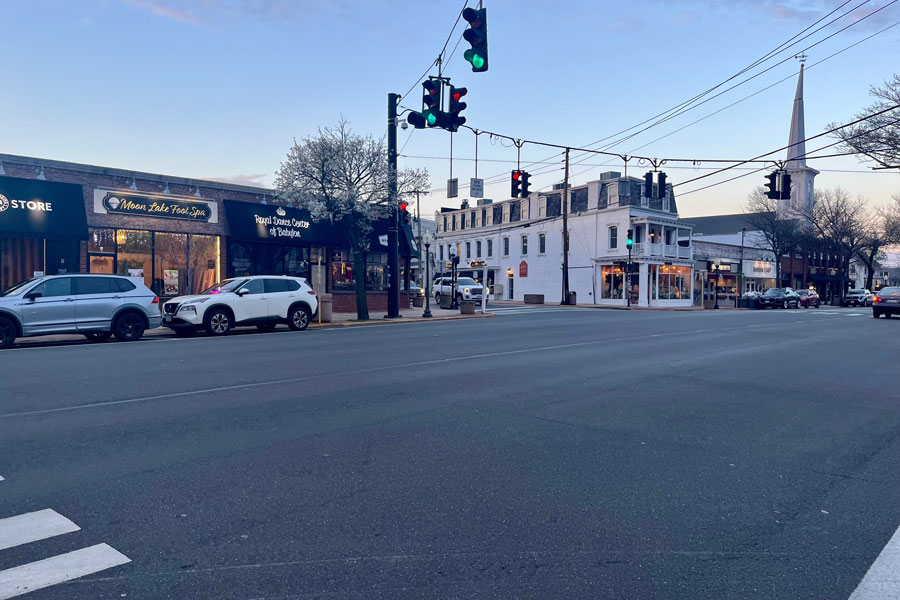 Evening view of Deer Park Avenue (NY-231) at the intersection of Main Street and Montauk Highway in Babylon Village, New York, featuring the historic downtown business district and local storefronts along one of western Suffolk County’s most recognizable commuter corridors.