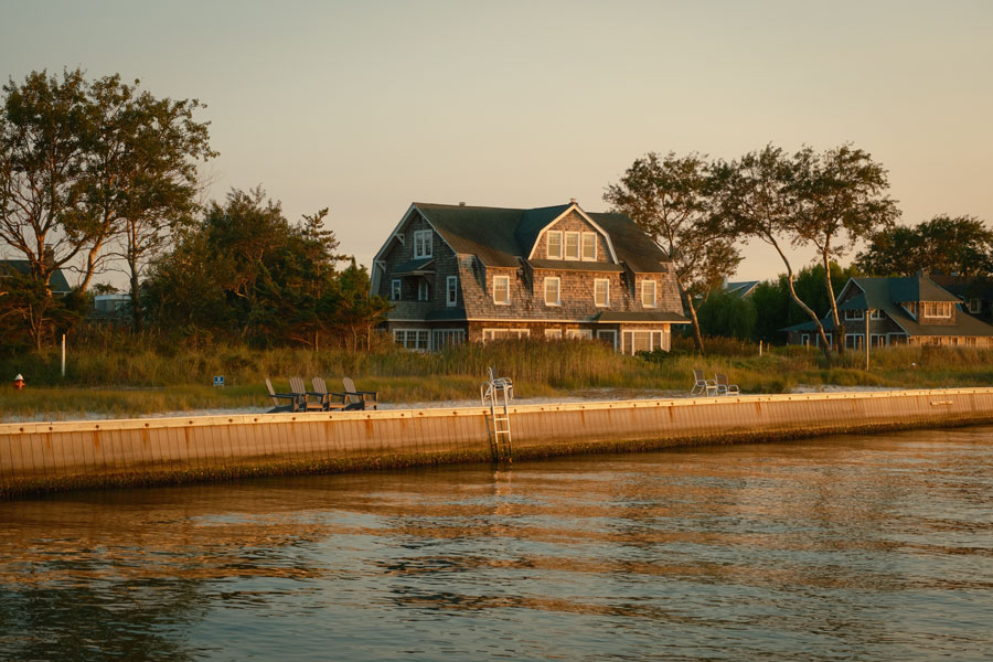 Charming waterfront homes line the Great South Bay in Saltaire, Fire Island, where private docks, coastal architecture, and peaceful surroundings reflect the village’s relaxed, residential character. The calm bay waters offer a quieter contrast to the ocean beaches just steps away. File photo: licensed.