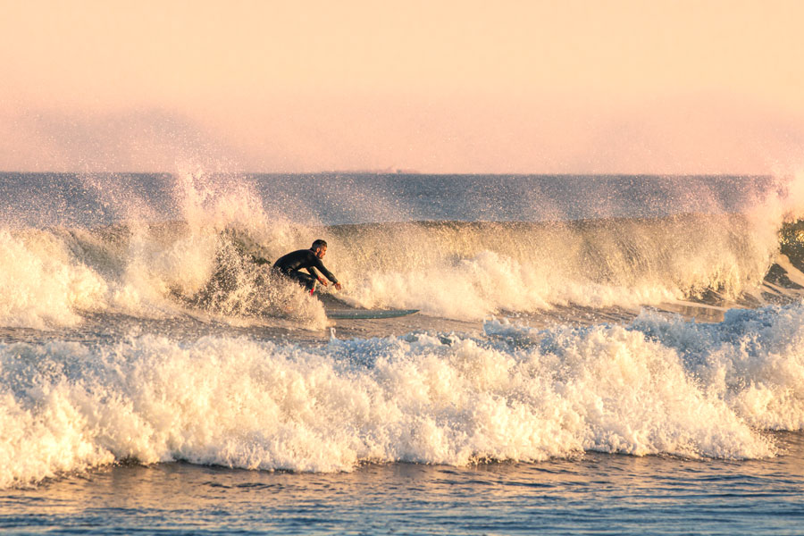 A surfer rides powerful waves along Long Island’s South Shore coastline near the waters connected to South Oyster Bay. The bay’s proximity to Jones Beach, barrier islands, and Atlantic Ocean inlets makes the surrounding region popular for boating, fishing, surfing, and other coastal recreation. File photo: licensed.