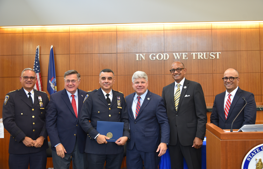 Chief of Public Safety for Suffolk Courts David Santiago is recognized for his distinguished tenure of service of more than 30 years in uniform. He is surrounded by (L-R): Deputy Chief of New York’s Office of Court Administration Frank Casiano, County Executive Edward Romaine, Suffolk District Administrative Judge Andrew Crecca, First Deputy Chief Administrative Judge Norman St. George, and Presiding Justice of the Appellate Division for the 2nd Department Hector LaSalle.