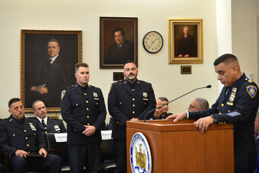 Chief of Public Safety for Suffolk Courts David Santiago shares with the audience the heroic acts by Officers Lloyd Booth (L) and Jonathan Leone (R) when assisting a police officer during the arrest of a combative civilian.