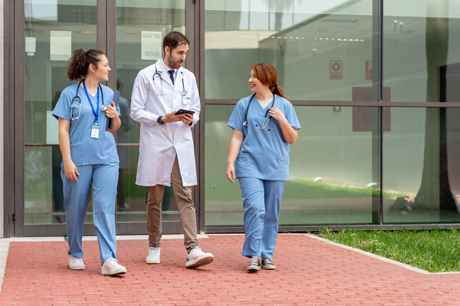 Healthcare professionals walk outside a medical facility. Education and health services remained Long Island's largest employment sector in June, accounting for approximately 330,200 payroll jobs, according to the latest U.S. Bureau of Labor Statistics report.