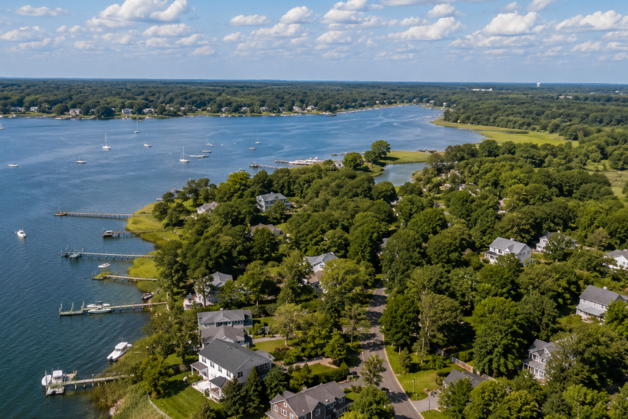 An aerial view of Noyack, New York, highlights the hamlet's tranquil waterfront setting along Noyack Bay, where wooded neighborhoods, private docks, and winding shoreline create one of the Hamptons' most peaceful residential communities. Surrounded by protected coastal waters and natural landscapes, Noyack offers a quiet maritime lifestyle just minutes from the historic village of Sag Harbor.